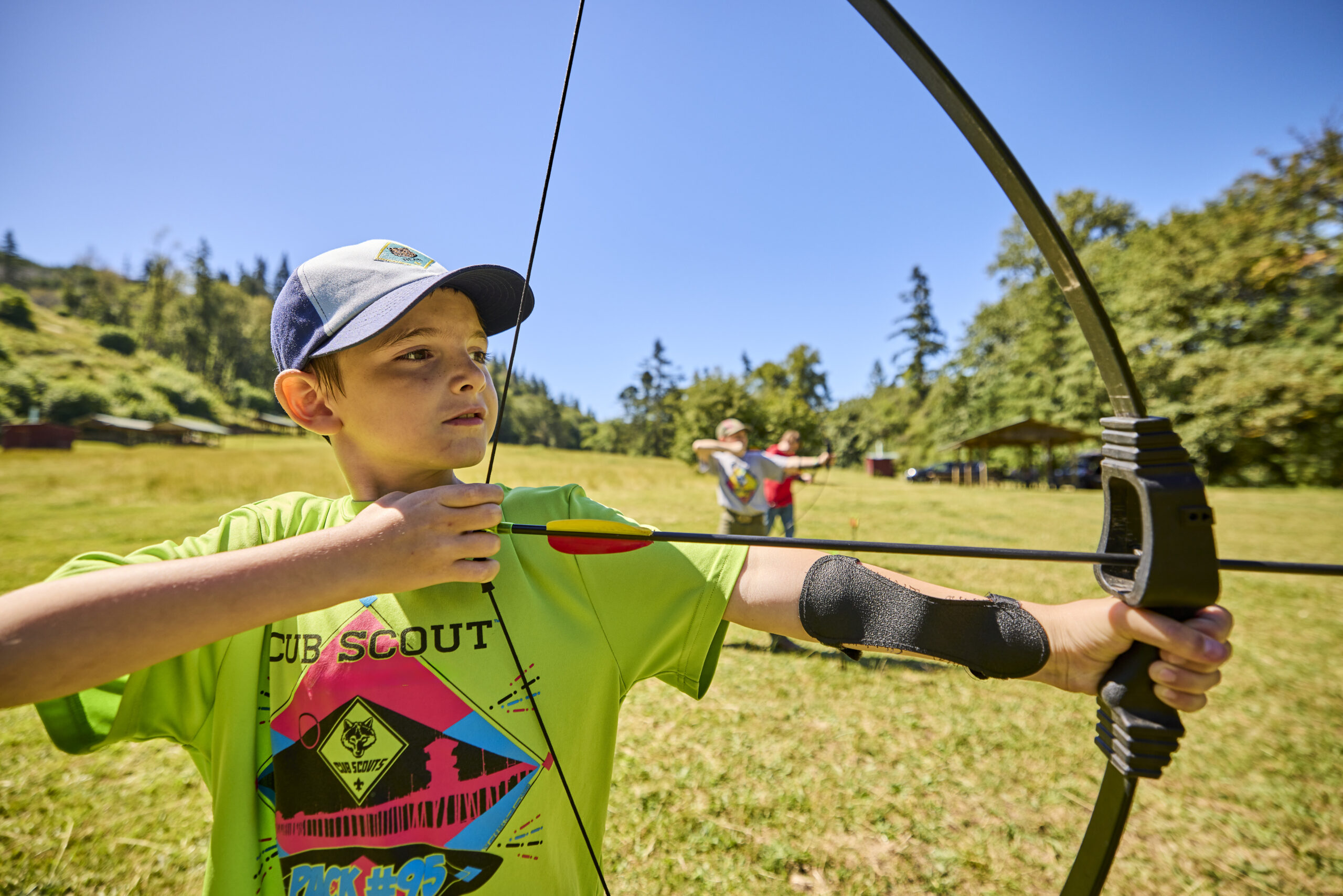 Cub Scouts at an archery range shooting bows and arrows